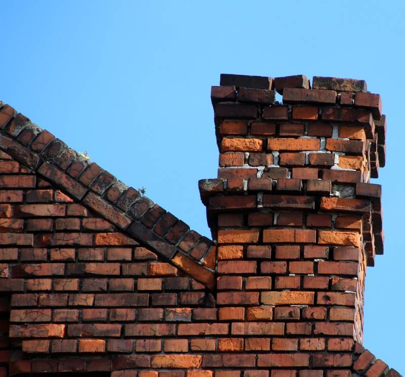 Damaged chimney on an Clinton home showing cracks and missing mortar